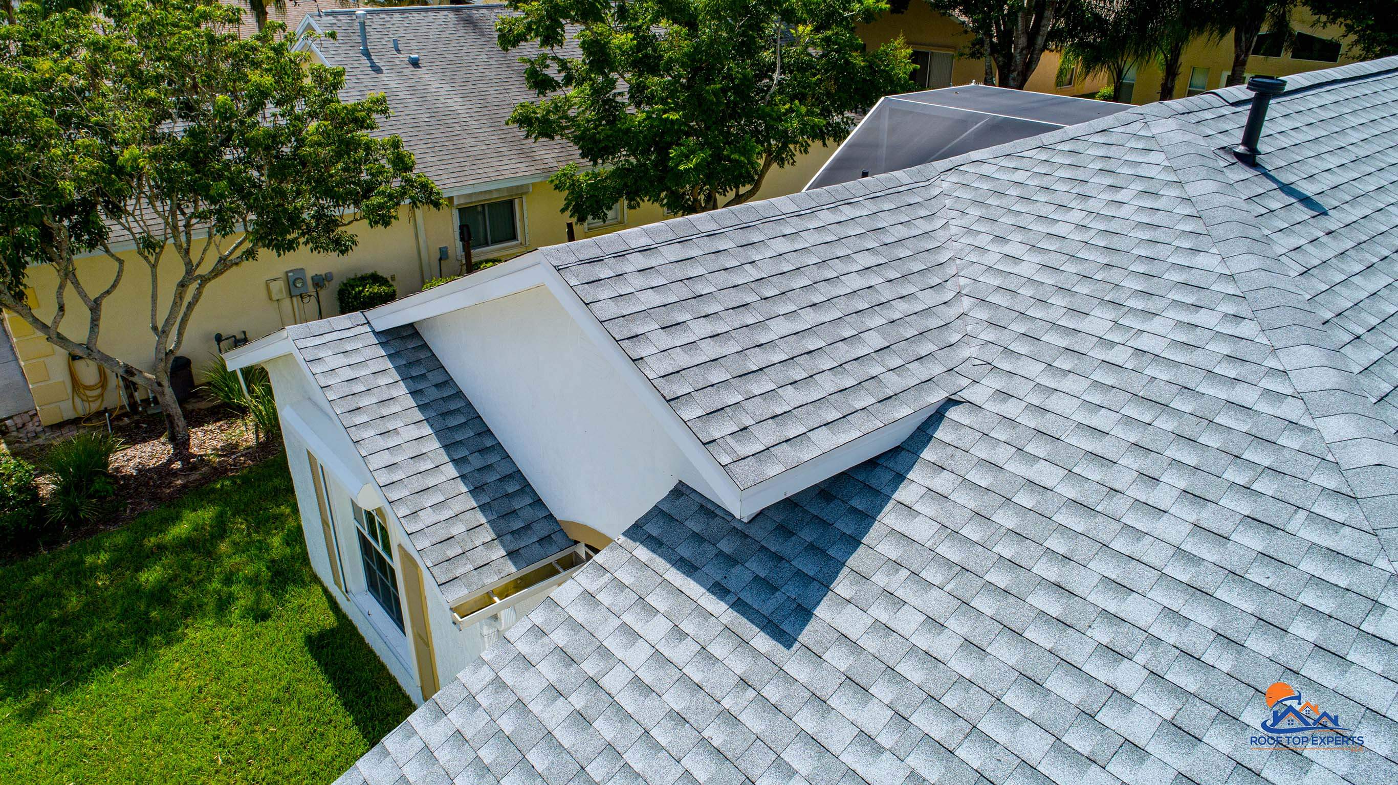Residential roof replacement featuring a GAF roofing system in Birchwood color, providing durable and stylish protection for homes.